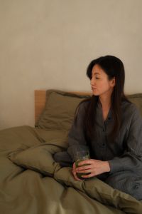 Kaboompics - Woman Relaxing in Bed with a Green Smoothie