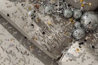 Kaboompics - Overhead View of Disco Balls and New Year’s Eve Confetti on a Neutral Couch