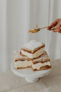 Kaboompics - Powdered Sugar Falling onto Napoleonka Squares on a Cake Stand