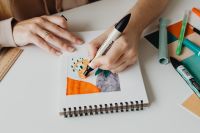 Kaboompics - Close-Up of Hand Coloring an Orange and Green Illustration with a Marker