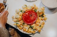 Kaboompics - Overhead Party Appetizer Skewers Arranged Around a Bowl of Red Sauce