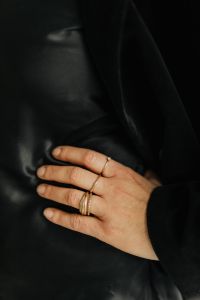 Kaboompics - Close-Up Woman's Hand with Layered Gold Rings on Black Fabric