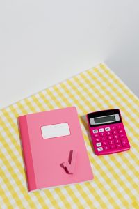 Kaboompics - Pink Notebook and Calculator on Yellow Gingham With Copy Space
