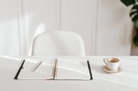 Kaboompics - Minimal White Desk with Open Weekly Planner, Silver Pen and Coffee Cup