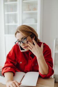 Kaboompics - Concerned Woman Holding Phone to Ear while Working from Home