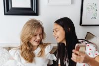 Kaboompics - Laughing Teen Girls Sharing a Smartphone During a Casual Sofa Hangout