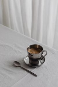 Kaboompics - Chrome Coffee Cup and Spoon on Silver Saucer