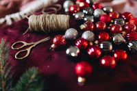 Kaboompics - Christmas Baubles with Scissors and Twine on Burgundy Fabric