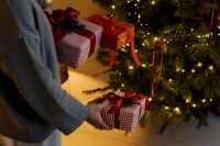 Kaboompics - Person Holding Wrapped Christmas Gifts by Lit Tree