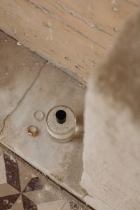 Kaboompics - Gold Rings beside a Perfume Bottle on a Weathered Stone Surface, Minimalist Still Life