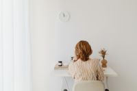 Kaboompics - Woman Sitting at Minimal White Desk beside Sheer Curtains