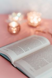 Kaboompics - Soft-Focus Open Book and Candlelight for a Pink Reading Background