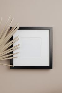 Kaboompics - Black Empty Picture Frame with Dried Palm Stems on a Warm Neutral Background