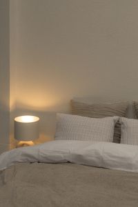 Kaboompics - Warm Bedside Lamp and Gray Bedding