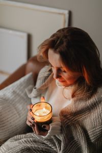 Kaboompics - Candlelight and Cozy Blanket: Woman Relaxing at Home