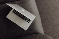 Kaboompics - Close up view of closed laptop lying on grey armchair