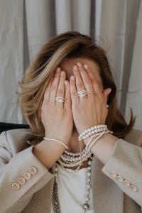 Kaboompics - Woman Covering Her Face with Pearl Jewelry and Beige Blazer