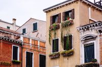 Kaboompics - Pink Venetian Facade with Green Shutters and Flower Boxes