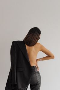 Kaboompics - Woman Posing with Black Blazer Draped over Bare Shoulder, Back View Fashion Portrait