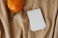 Kaboompics - Orange Fruit and Stacked Blank Business Cards in an Overhead Branding Mockup