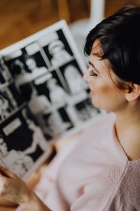 A woman with short dark hair reads a newspaper