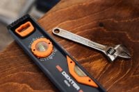 Kaboompics - Close-Up Digital Level and Adjustable Wrench on Textured Wood, Home Repair Still Life