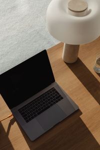 Kaboompics - Wooden Desk Still Life with Laptop, Water Glass and Stone Lamp