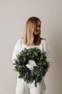 Kaboompics - Woman Holding Dark Green Christmas Wreath
