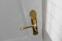 Kaboompics - Close-Up of an Ornate Brass Door Handle and Keyhole Beside White Subway Tile