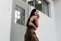 Kaboompics - Asian Fashion Model in Black Sleeveless Top and Brown Wrap Skirt against White Wall