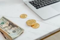 Kaboompics - US Dollar Bill and Bitcoin Tokens Beside Laptop