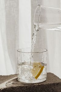 Kaboompics - Water Pouring From Glass Carafe Into Lemon Garnished Glass