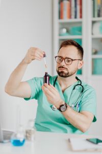 Kaboompics - Doctor Holding Pipette and Dropper Bottle