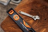Kaboompics - Digital Spirit Level and Adjustable Wrench on a Rustic Wooden Surface, DIY Repair Tools