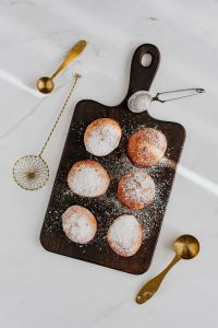 Kaboompics - Overhead Pączki Flat Lay with Gold Spoons and Sugar Sifter