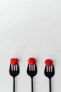 Kaboompics - Three Raspberries On Forks Vertical Composition