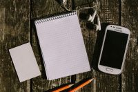 Kaboompics - Vintage Samsung Phone, Earphones and Grid Notebook Flat Lay