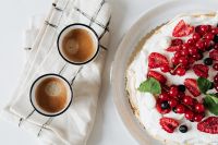 Kaboompics - Minimal Berry Pavlova and Espresso Flat Lay with Bright White Negative Space