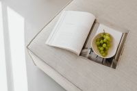 Kaboompics - Top View of an Open Book and Grapes on a Neutral Sofa