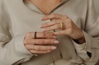 Kaboompics - Hands Displaying Gold Rings Against a Beige Shirt