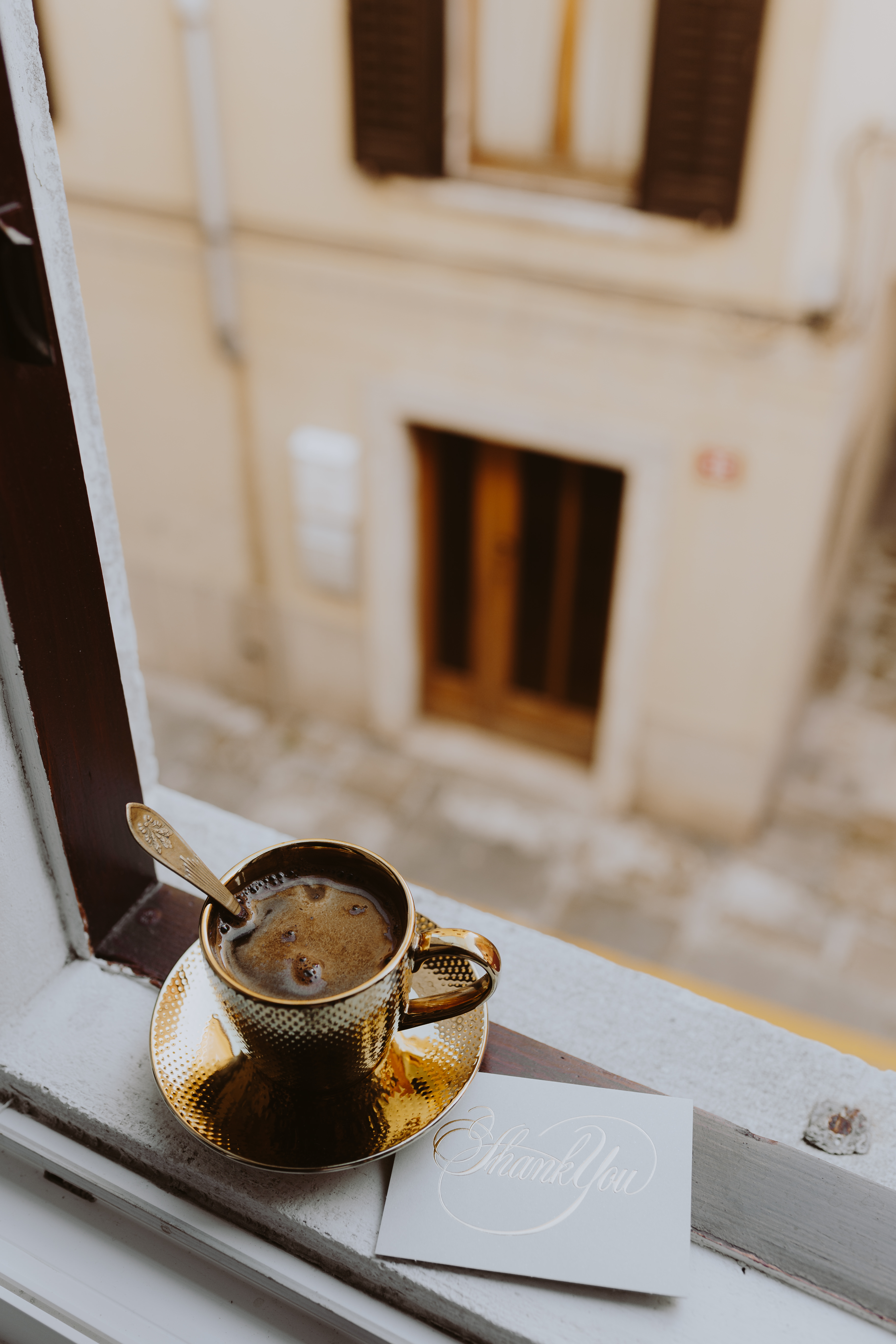 Drink coffee in a golden cup at the window