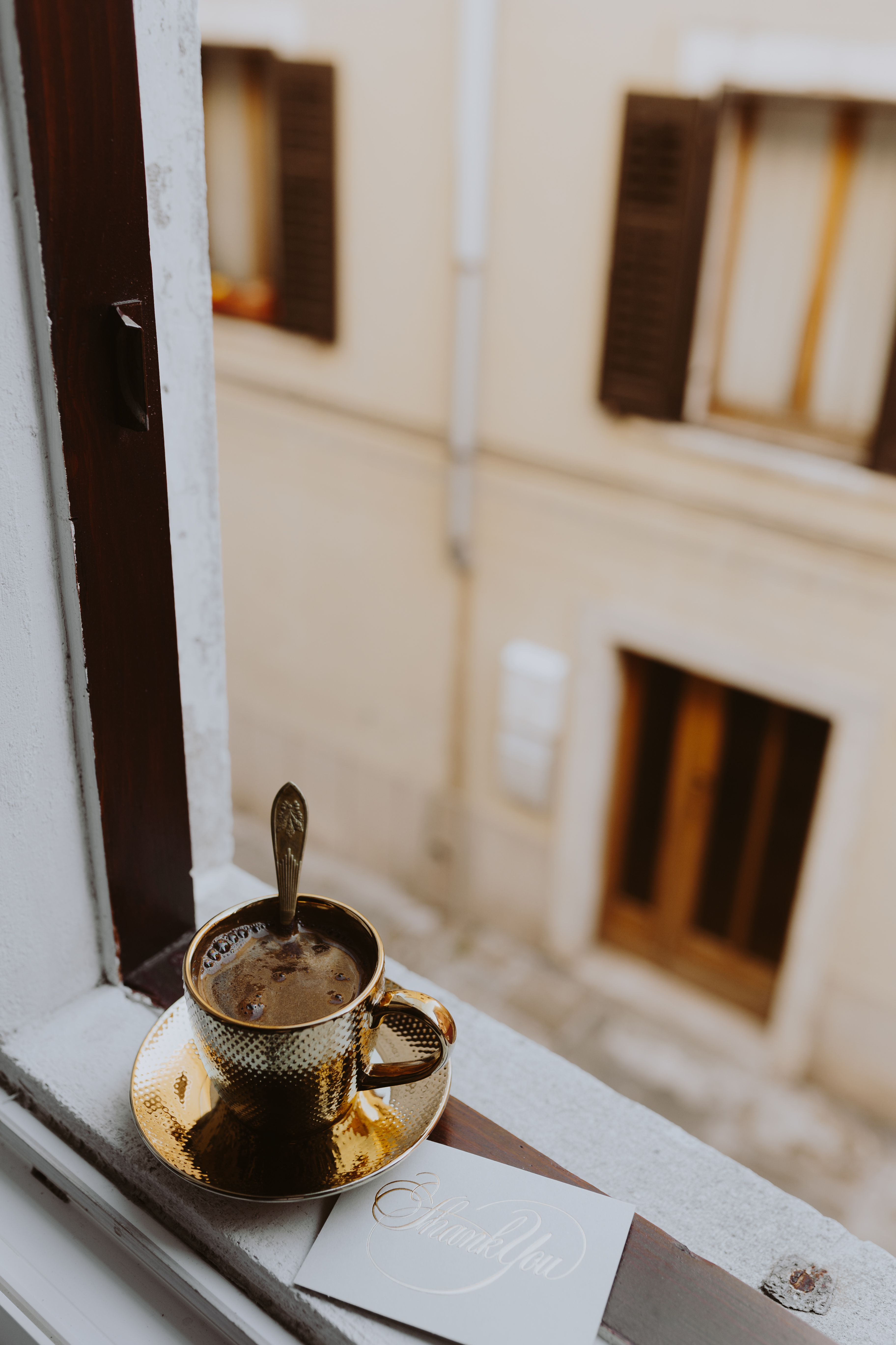 Drink coffee in a golden cup at the window