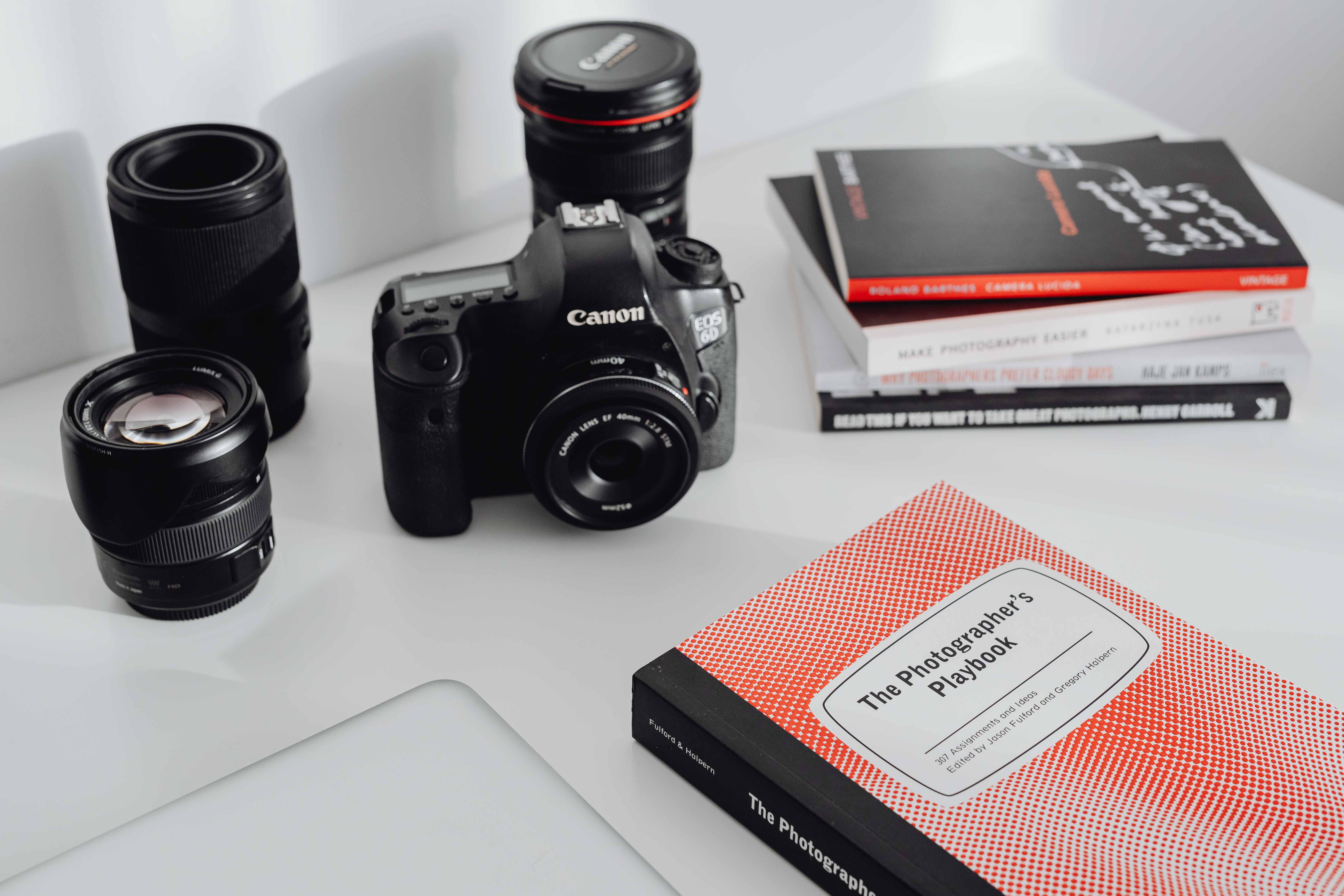 Photographer's desk - books, DSLR camera and lenses