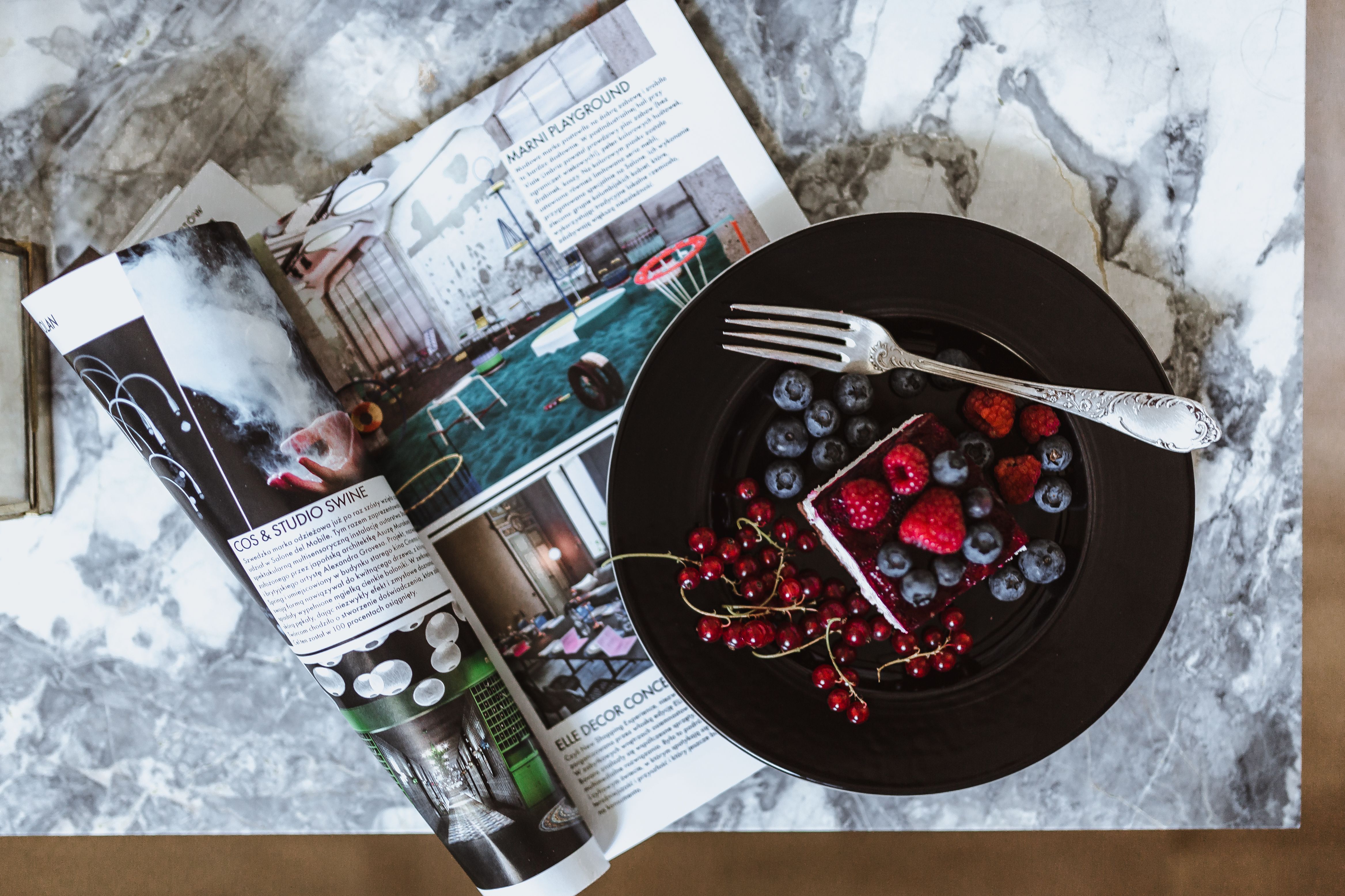 Cheesecake and magazine on a marble table