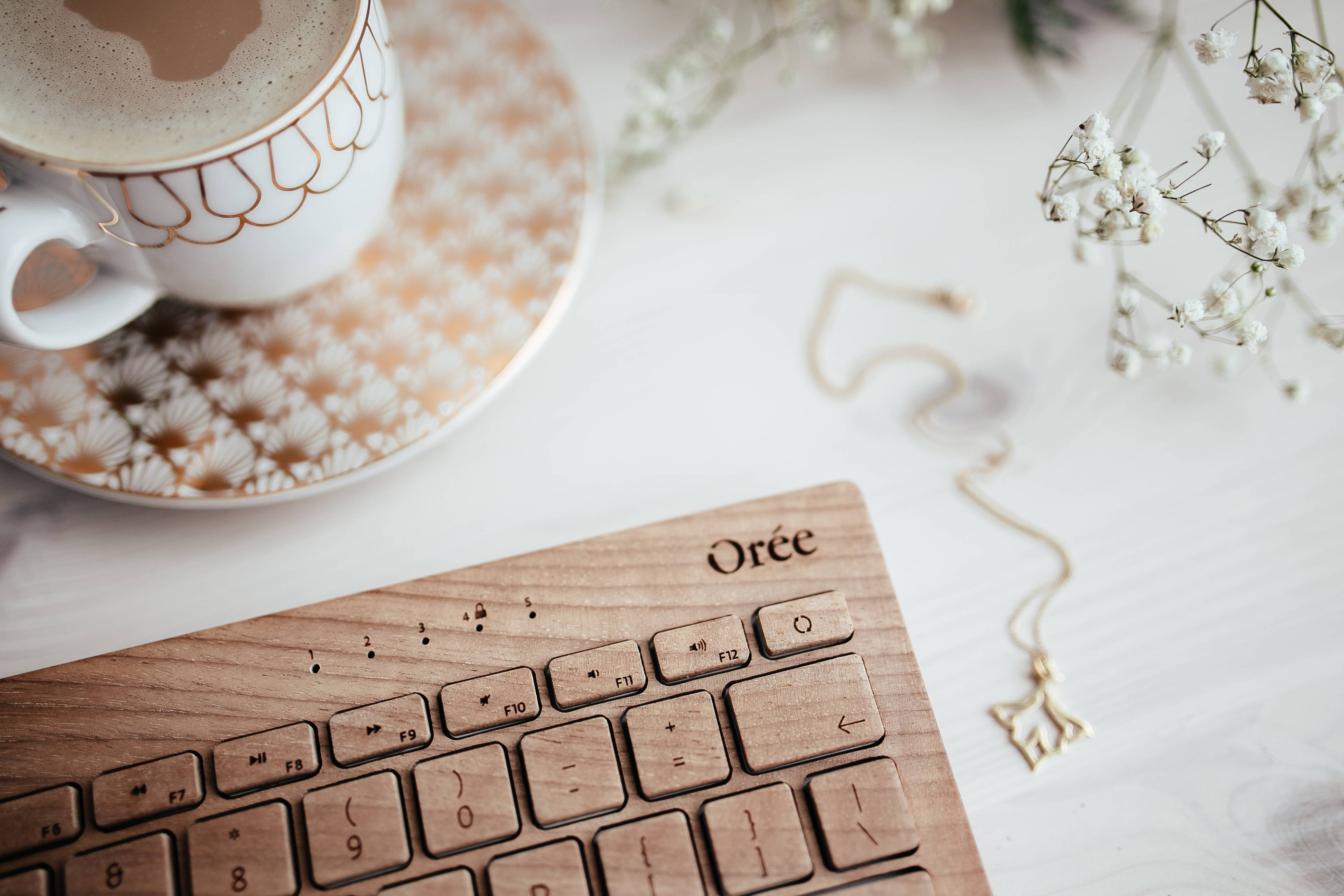 Wooden keyboard, coffee and golden jewellery