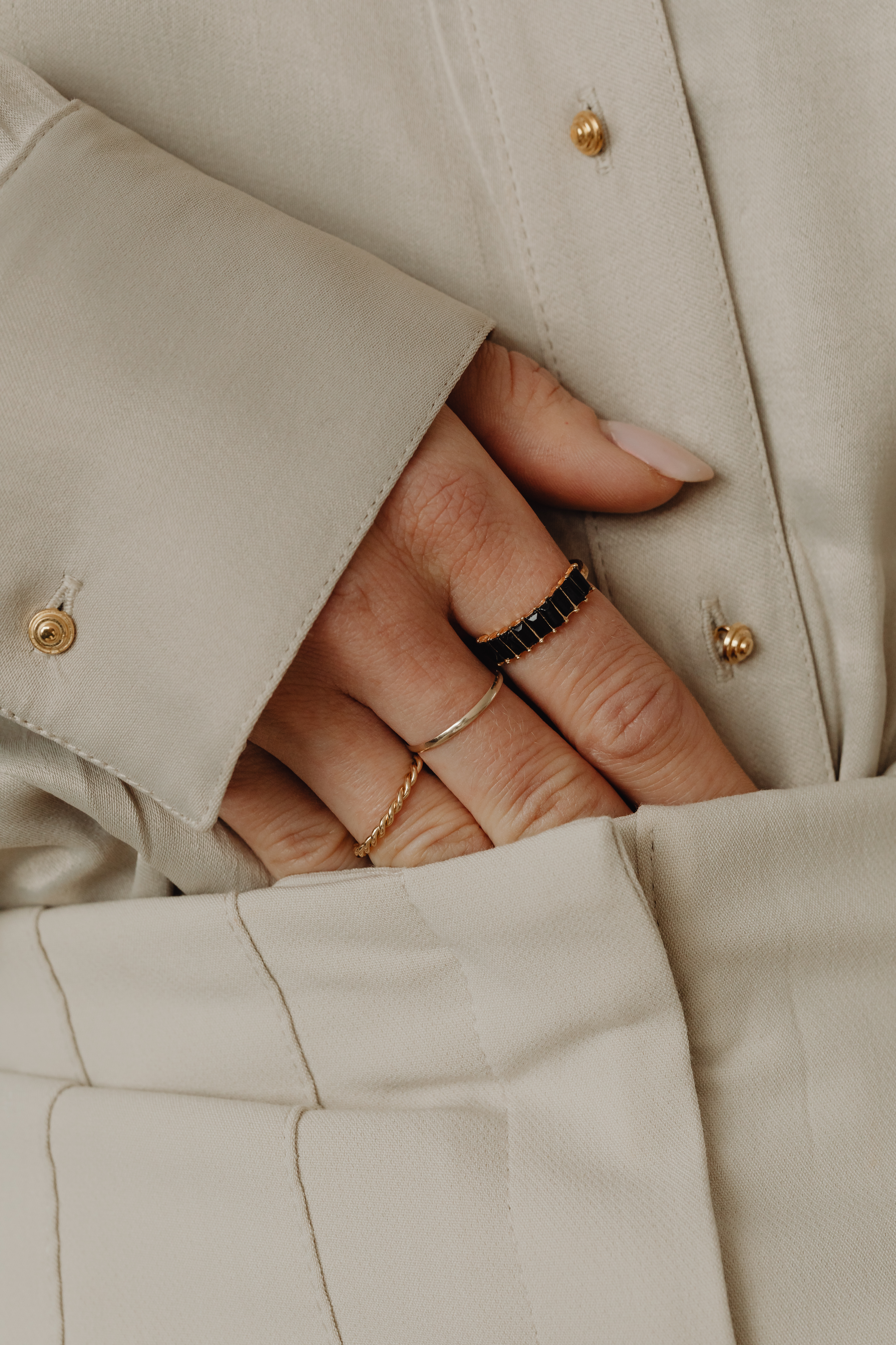 Details of gold jewelry - beautiful woman wearing a tan silk shirt