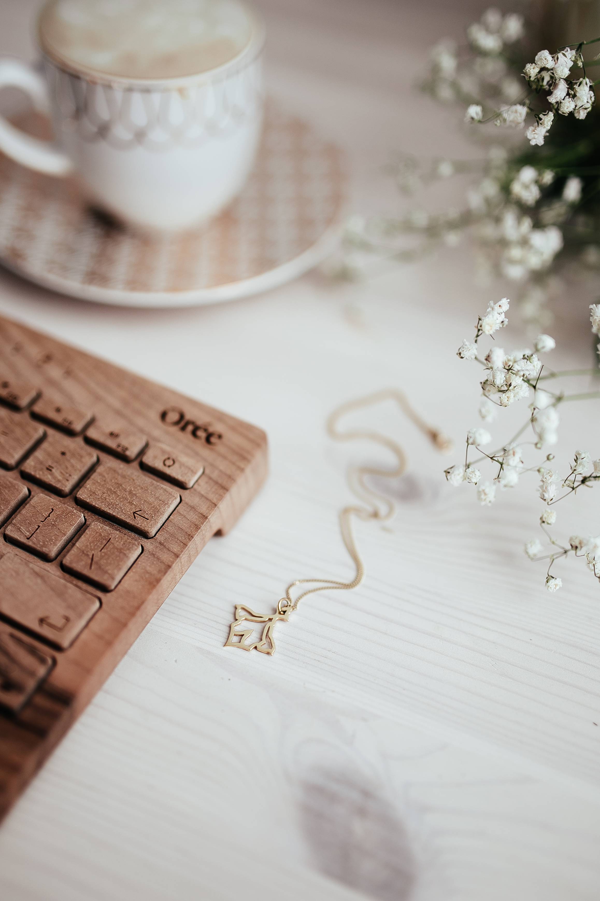 Wooden keyboard, coffee and golden jewellery