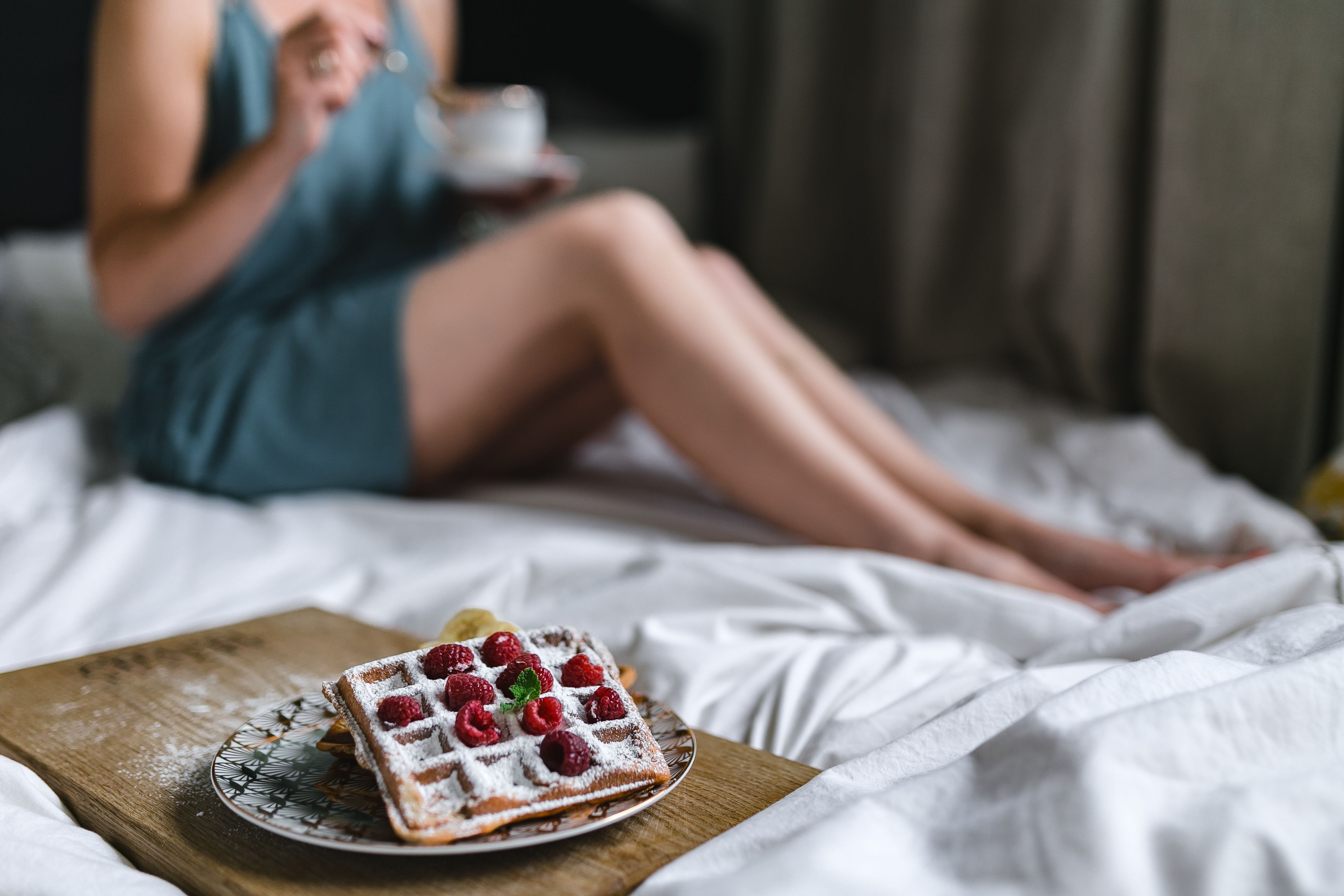 Beautiful young woman having breakfast in the bed