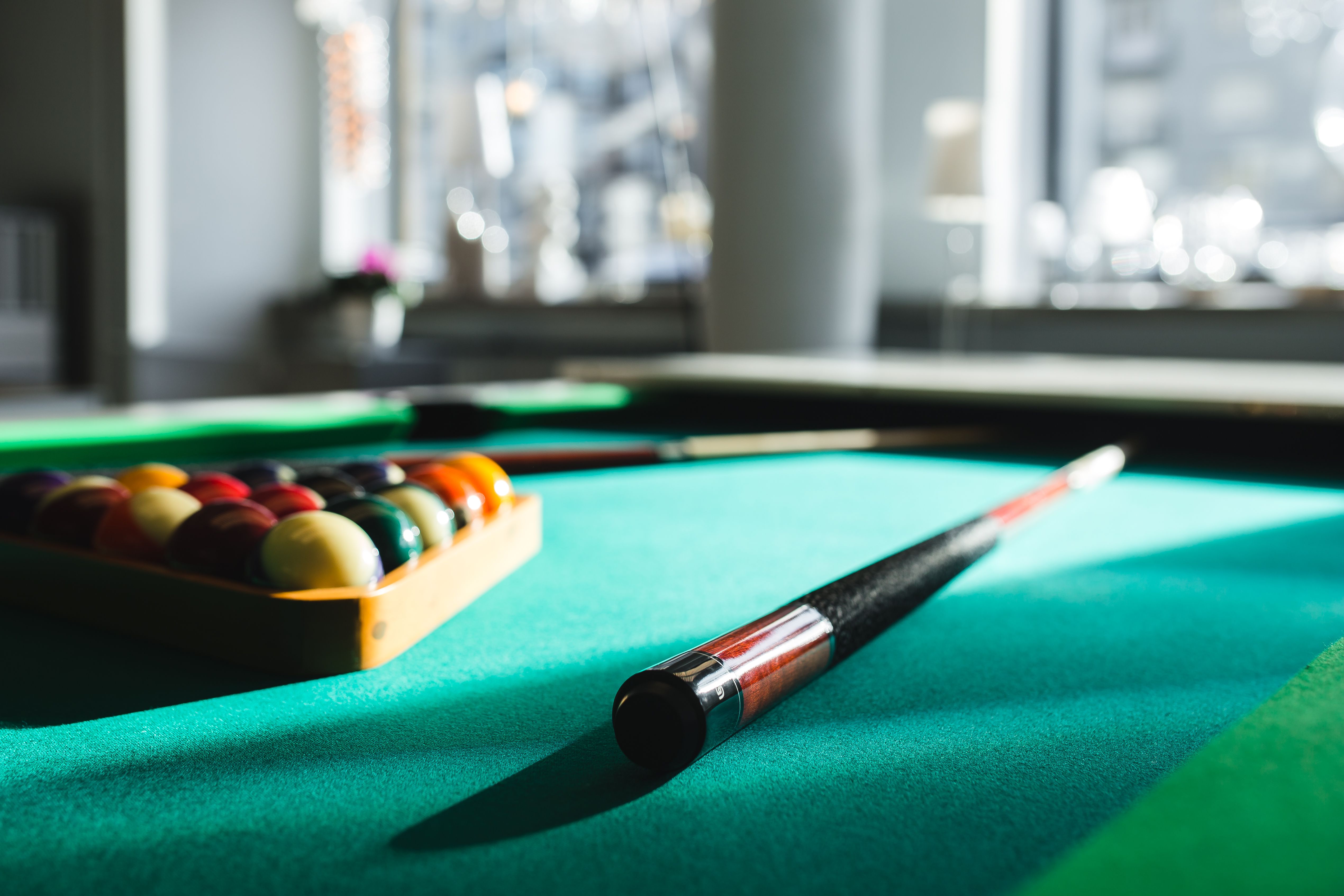 Billiard balls on green table with billiard cue