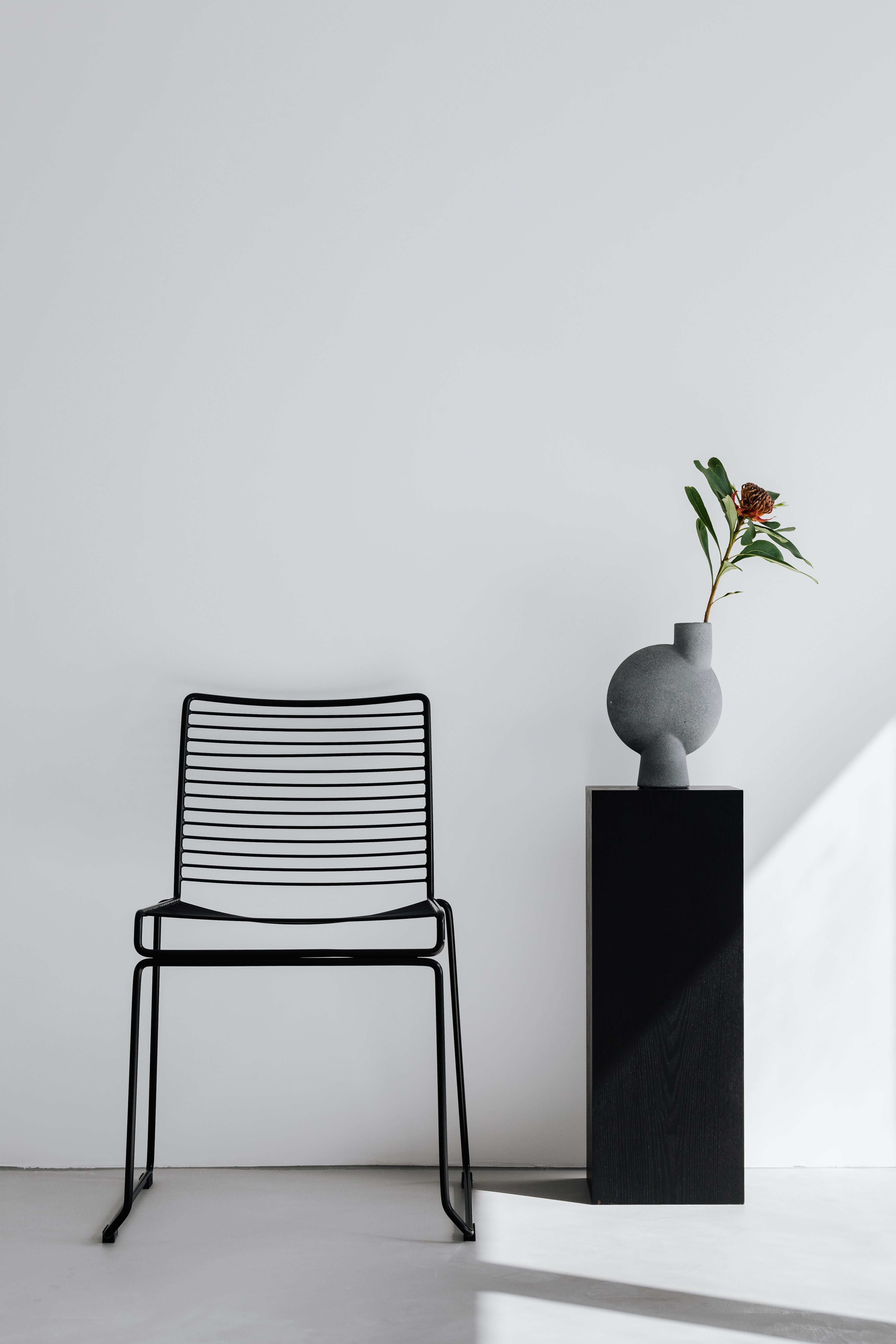 Black metal chair - flowers - modern vase - pedestal